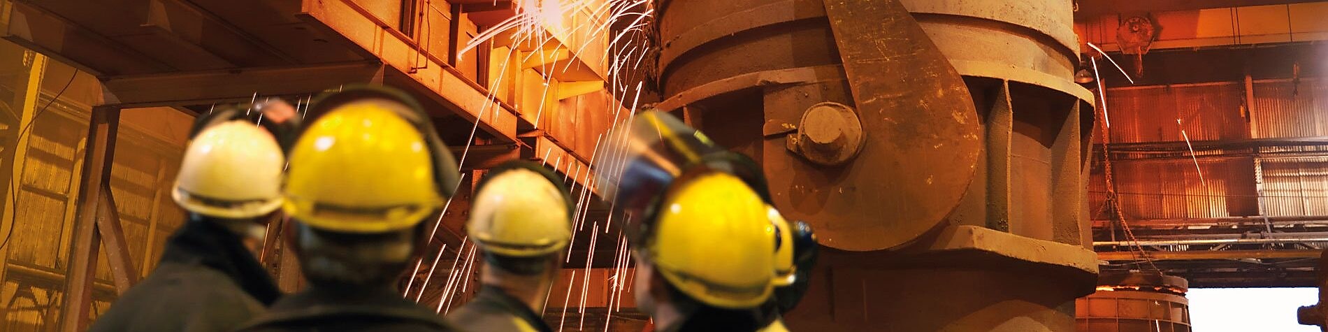 workers watching heavy machinery in a metal processing plant