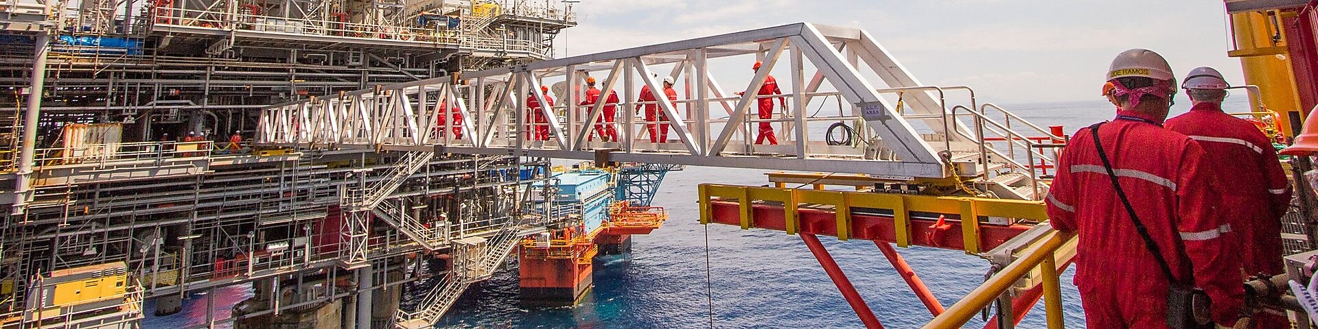 Workers cross over to a new platform built alongside the existing Malampaya deep-water project