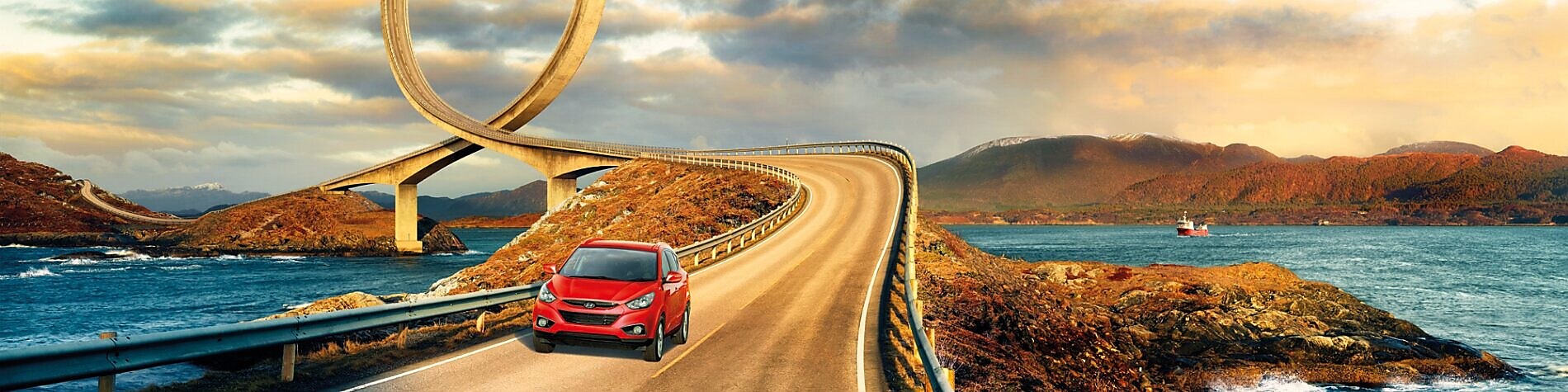 Red car driving on the road by the river