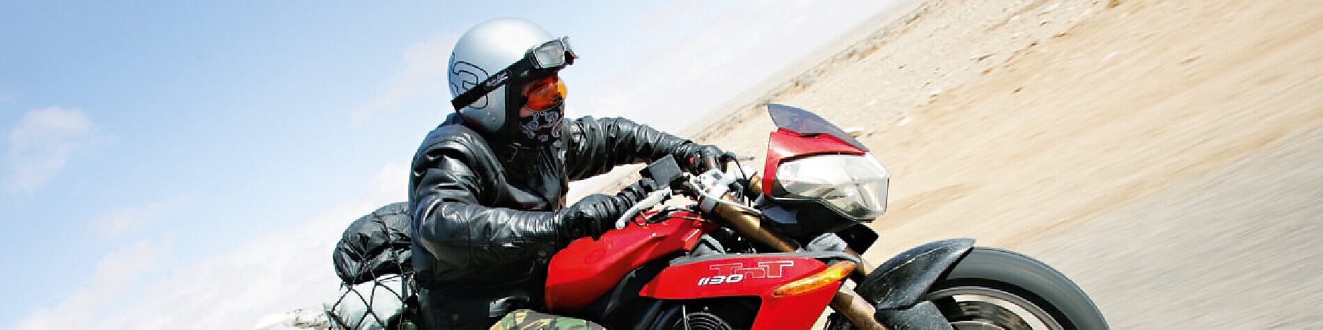 Gary Inman riding a motorbike through the dessert