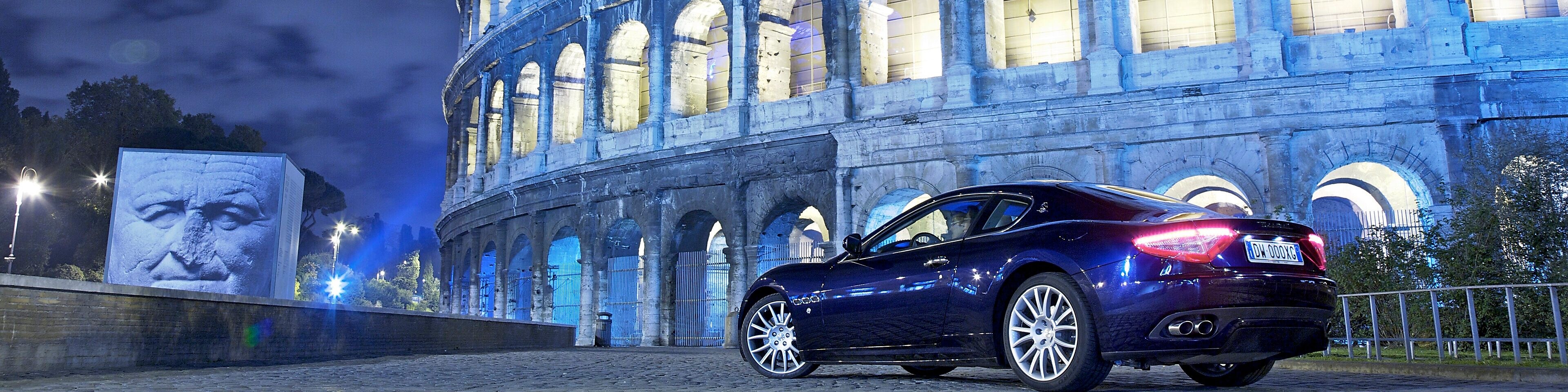 Car parked outside of the Colosseum in Rome at night