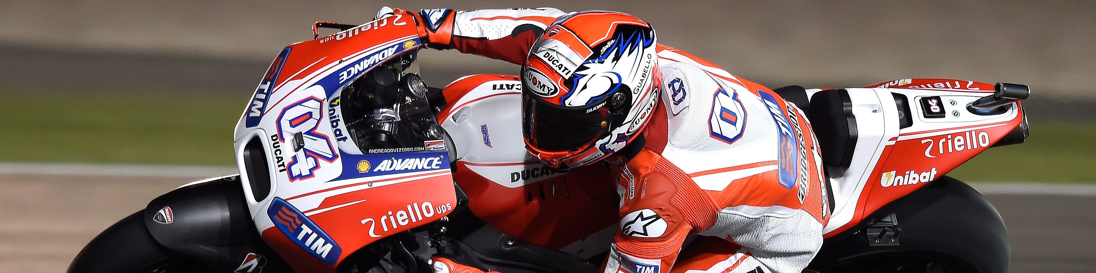 Motorcycle with rider racing around the corner of a track