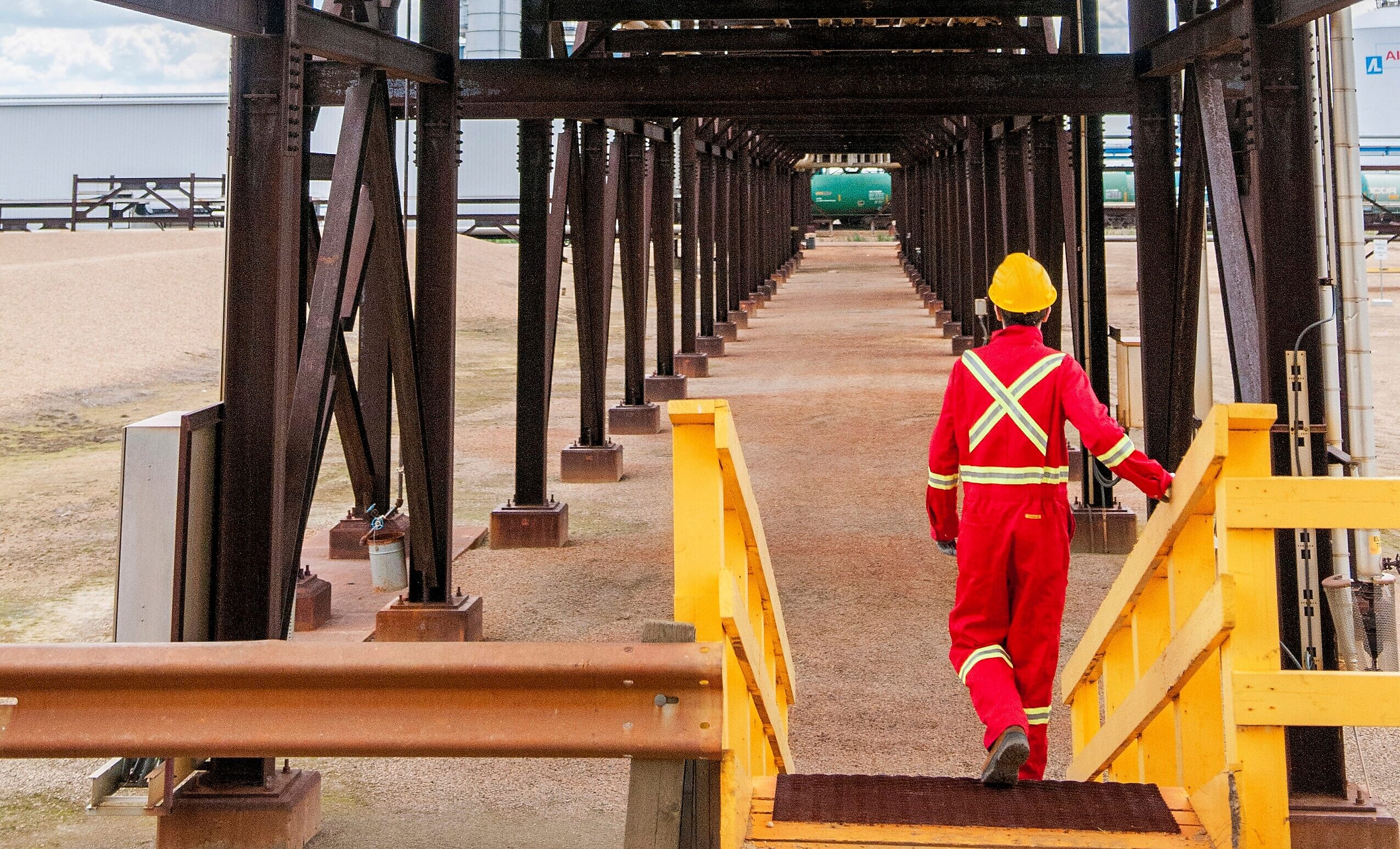 A Shell employee walking toward a reactor with FCC Catalysts.