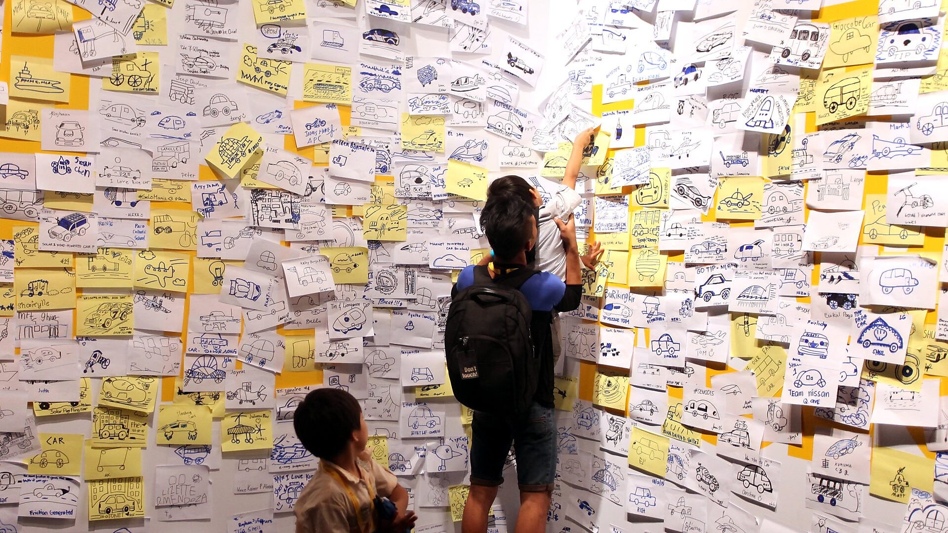 Visitors post 'ideas' on an interactive wall at the 'Experience' during day four of the Shell Eco-marathon 